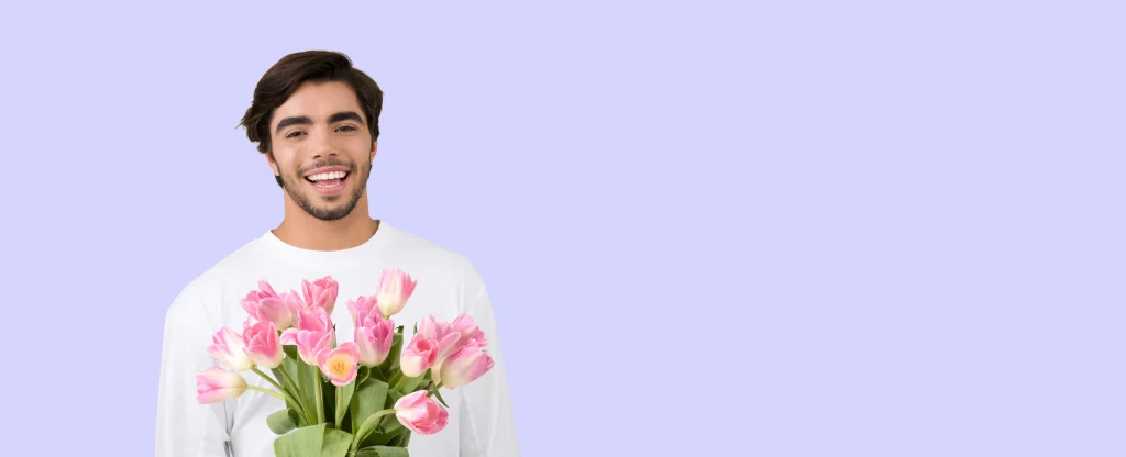 man smiling holding flowers