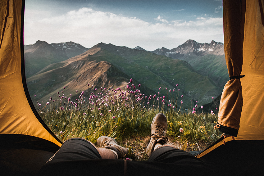 man in a mountains lying in the tent